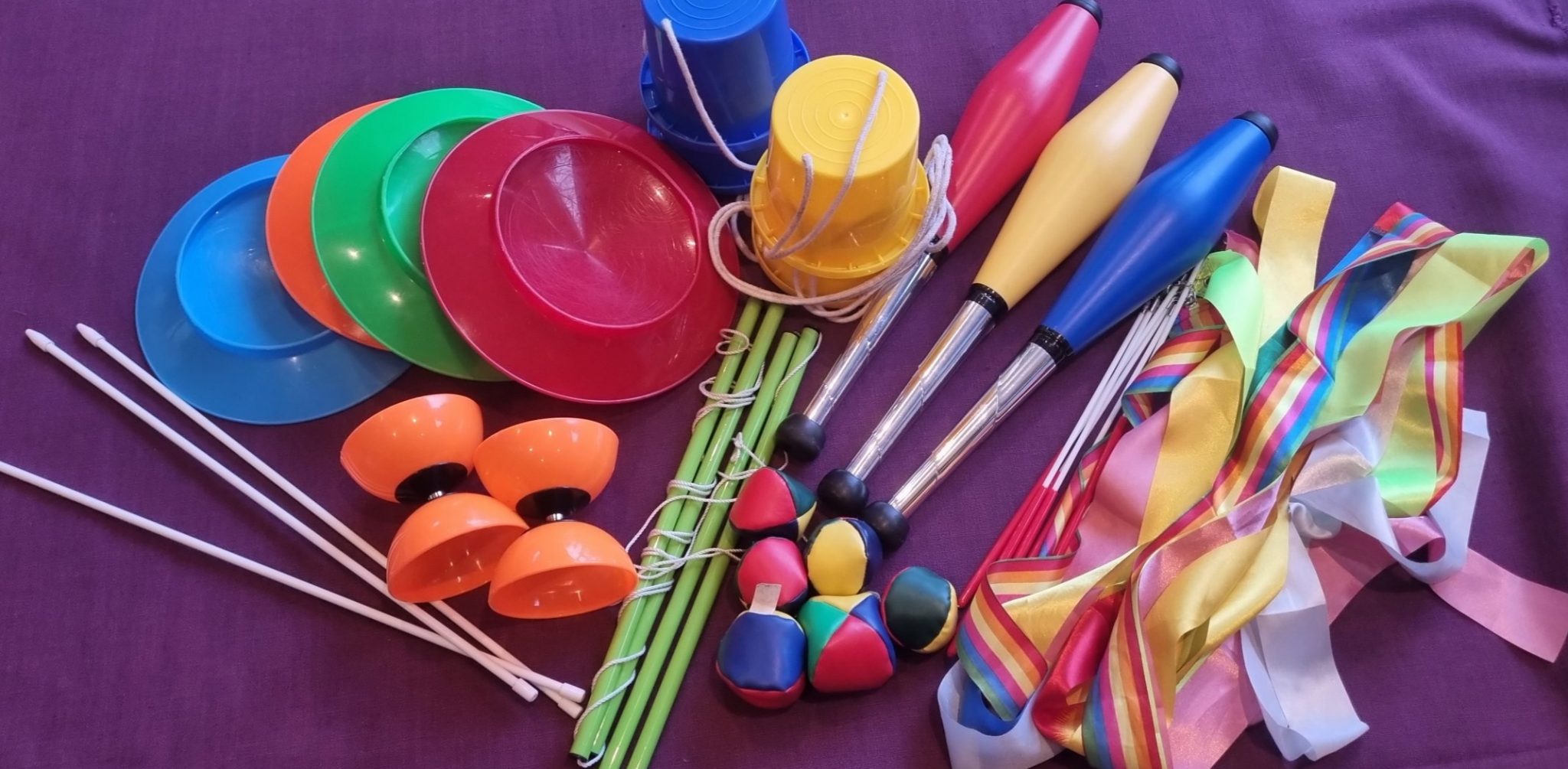 A flat lay of Circus skill toys for children- spinning plates, juggling balls, diablo